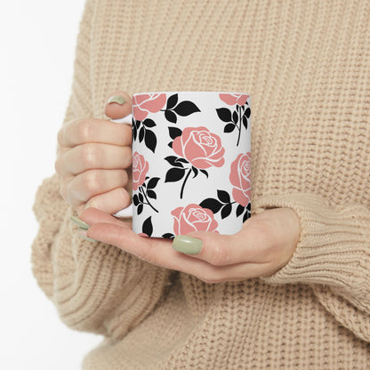 Person holding a mug with floral design against a neutral background