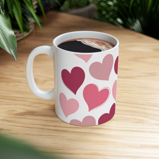 White mug with pink heart pattern on a wooden table